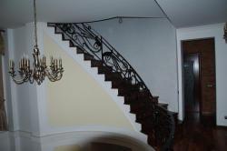 Монолитная винтовая лестница с коваными перилами