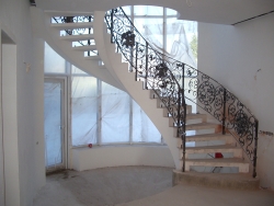 Лестница из бетона с  коваными перилами